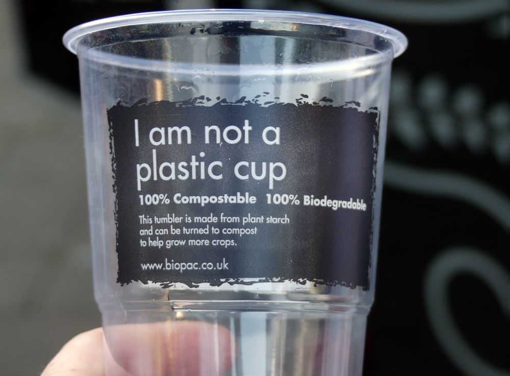 Hand holding compostable goods to drink from