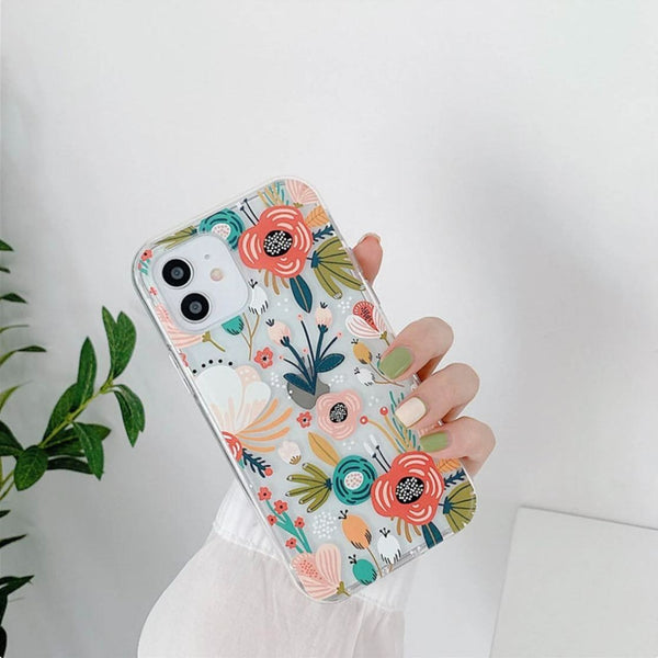 Hand holding two different clear floral phone cases