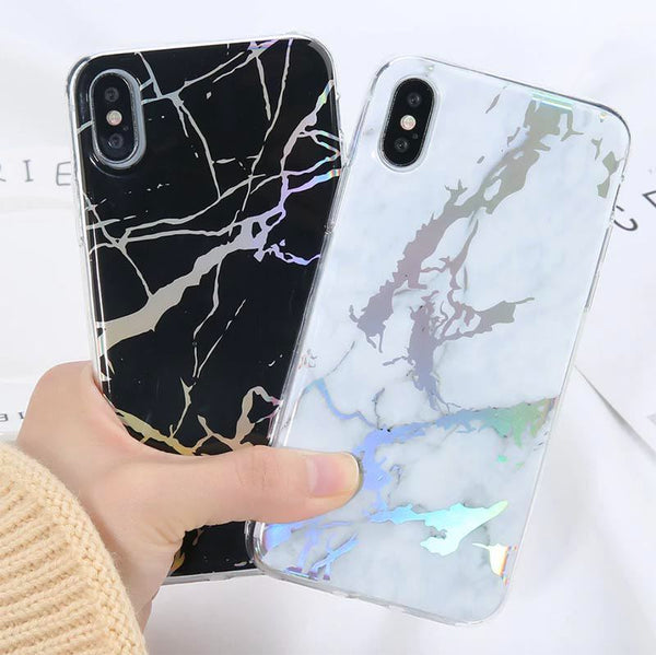 A hand holding one white marble case and one black