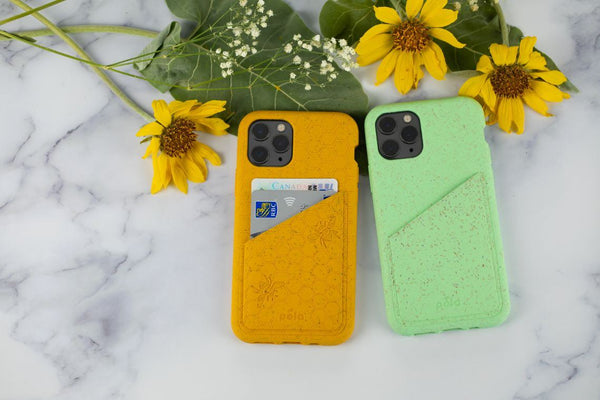 Two wallet cases on a marble surface with flowers