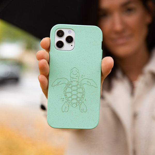 woman holding a turquoise phone