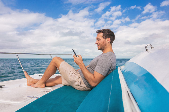 man using a mobile phone on a boat