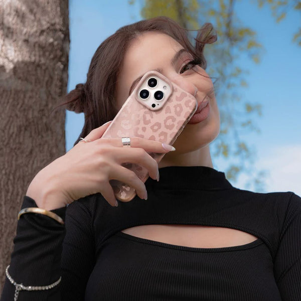 A woman holding up her nude leopard phone case up to her face