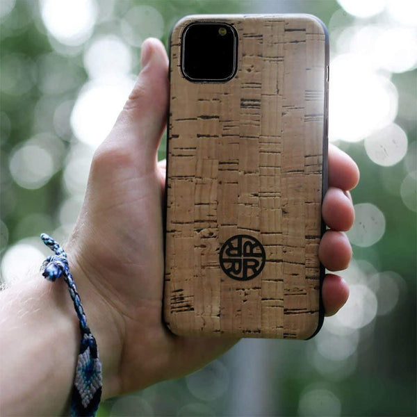A person holding up their phone in a cork phone case