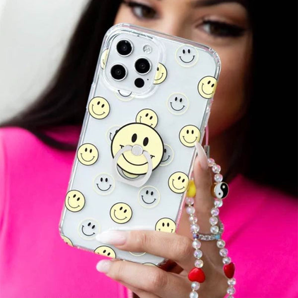 A girl holding a phone with a clear smiley face case on it