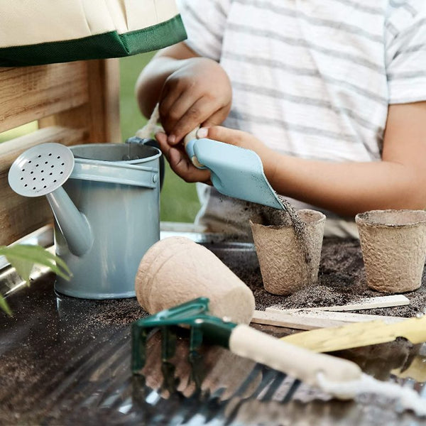 Child's hands pouring dirt into a plant pot