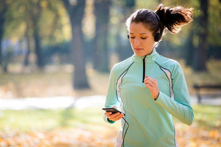 woman checking phone jogging