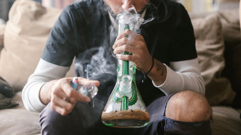 man smoking bong on couch