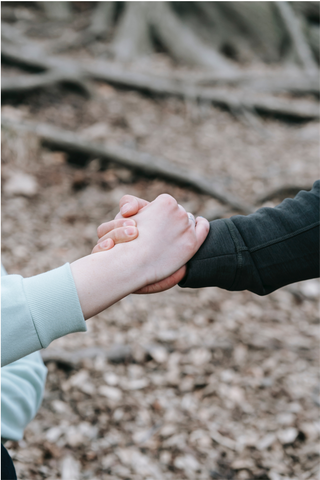 An image of two people holding hands as a sign of support for World Suicide Prevention day