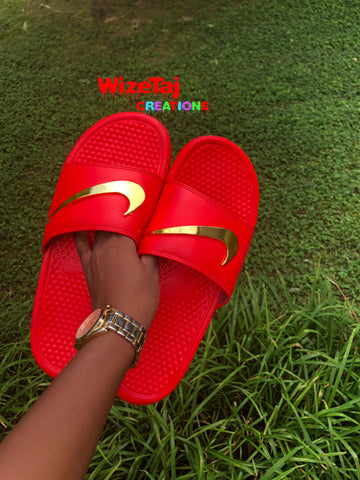 red nike sandals with gold check