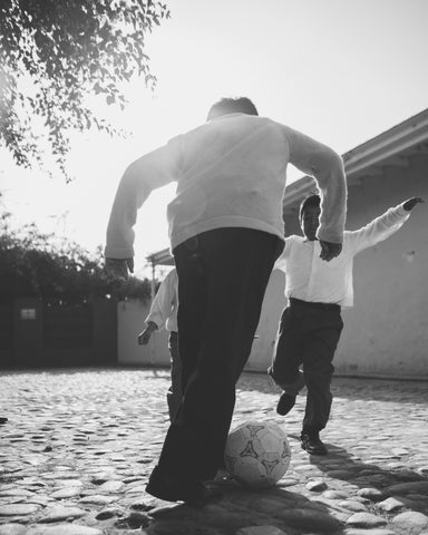 Father playing soccer with son