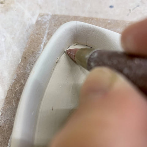 cleaning the clay from the handle mold