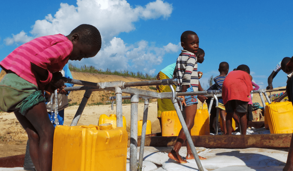 children getting water from water pipes with buckets