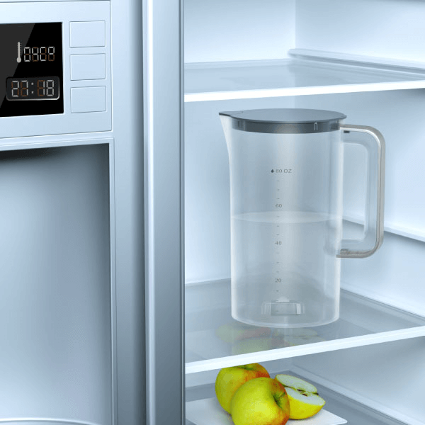 The water pitcher filled with water and being placed inside the refrigerator