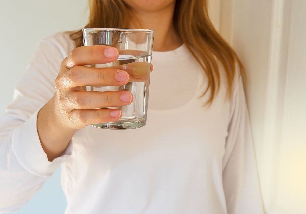 a woman holding a glass of clean water