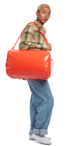 model sporting the Go-Bag — Small in the color Mandarin Red