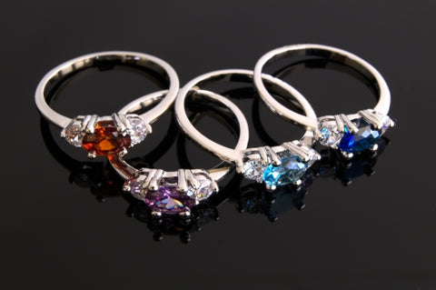 Image of four distinct rings with different birthstones and gems.