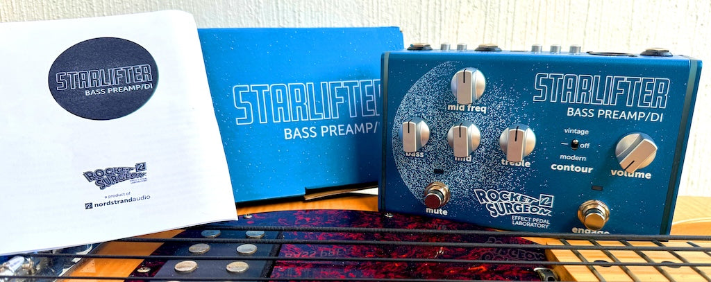 Nordstrand Audio Starlifter Bass Preamp/DI showing manual, box and preamp sitting on top of an OLP MusicMan® Style Bass Guitar with tape wound strings