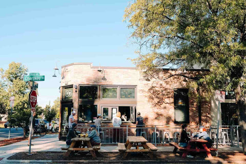 Patrons drinking outside at Queen City Collective Coffee, a Denver coffee roaster