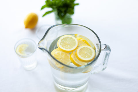 glass pitcher of water with lemon slices