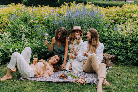 group-of-women-having-a-picnic-near-a-flower-garden