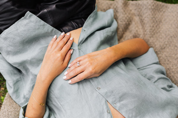 hands on stomach white nails blue button up shirt