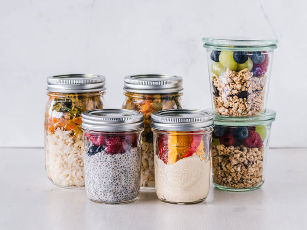 mason jars of snacks with granola chia seeds yogurt and fruit