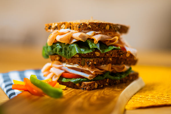 stacked turkey sandwich with lettuce and tomato
