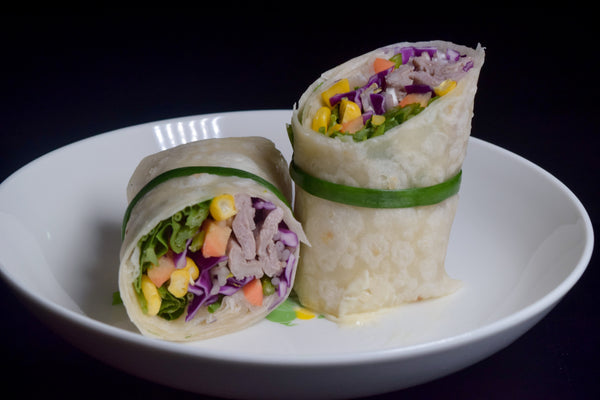 vegetable wrap cut in half on white plate