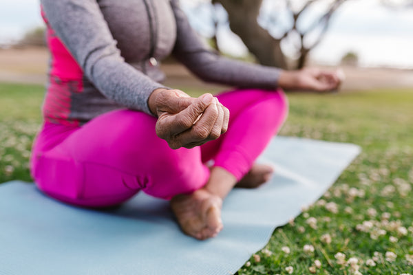 woman in pink pants doing yoga outside