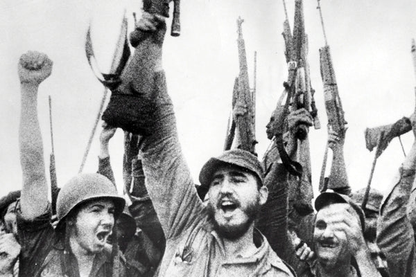 Fidel Castro raises a rifle in triumph