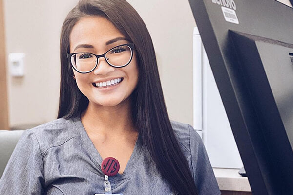 A smiling woman wearing glasses