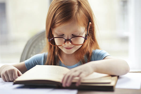 A little girl is reading a book