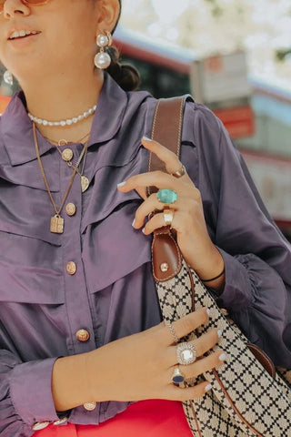 Street Style: Pearl earrings, minimal layered gold pendant chains, and boho rings