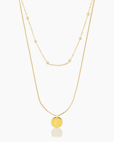 layered gold necklace with round pendant