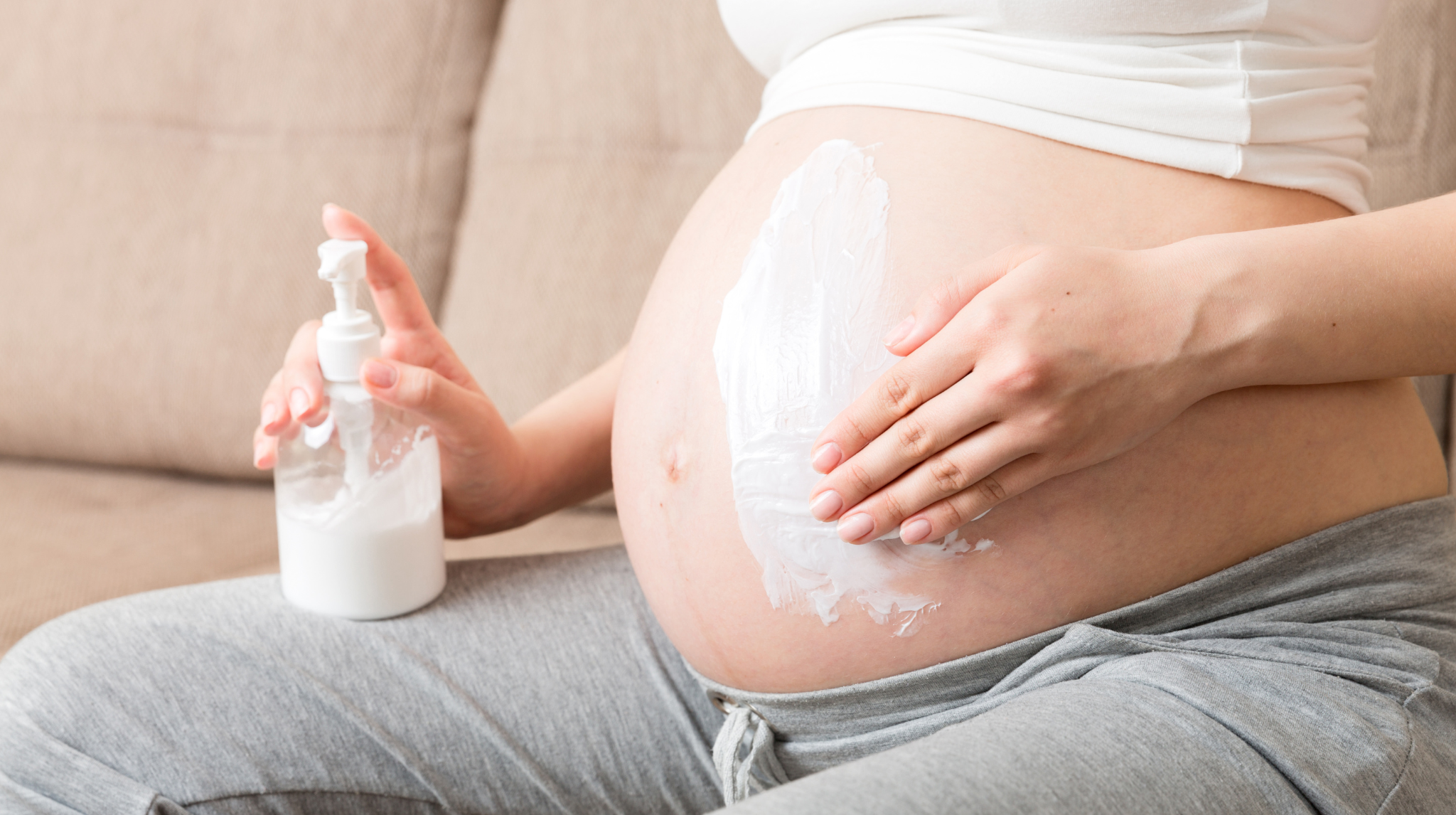 Pregnant woman applying stretch mark cream on belly | Neeva Baby