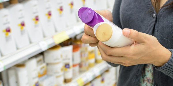 Woman looking at Shampoo Bottle Ingredients