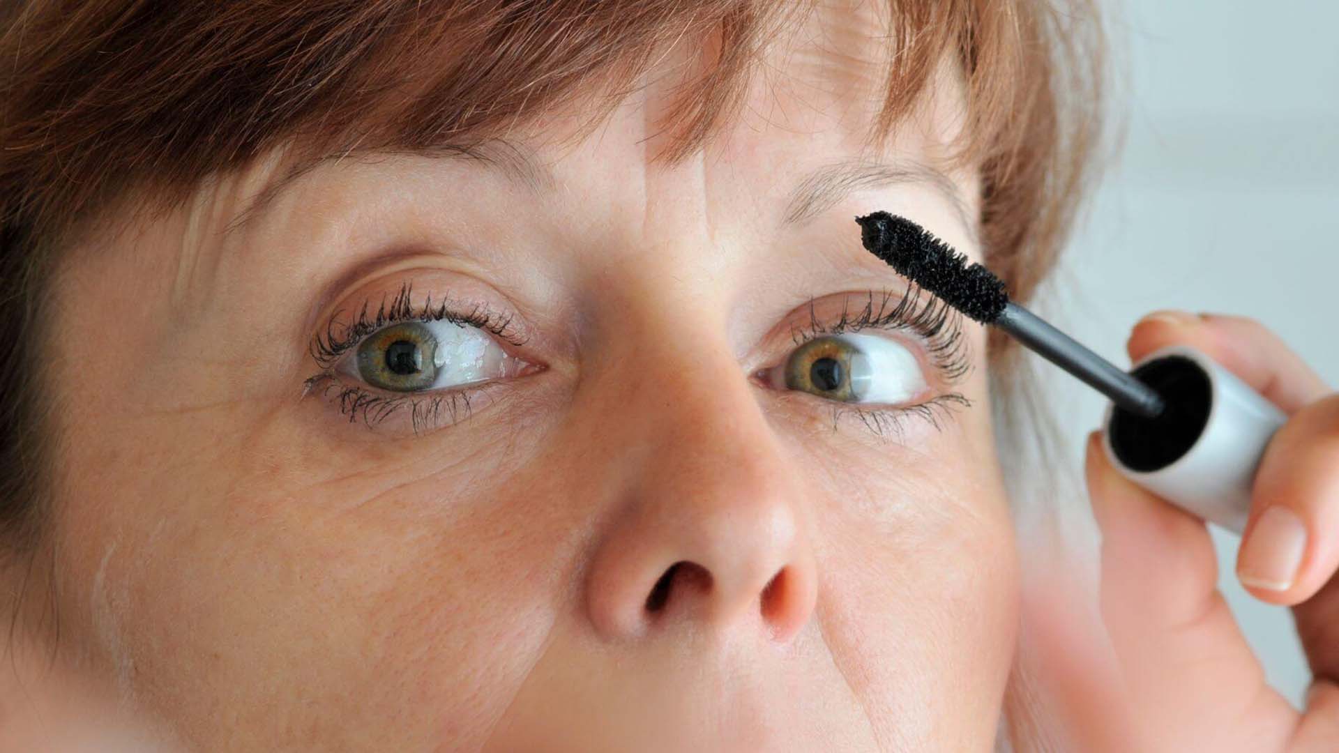 Woman putting on mascara