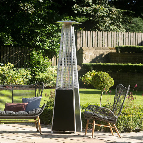 A black patio heater between two outdoor chairs