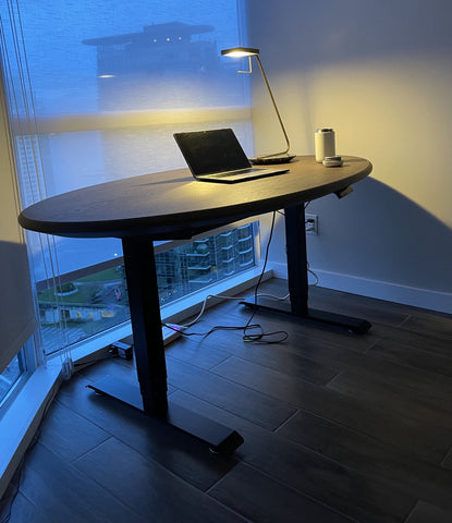 A Oval standing desk with macbook and lamp - #EFFYSETUP - DIY Standing Desk - Pairing Your Tabletop to a Sit-Stand Desk Frame - EFFYDESK Ergonomics Blog