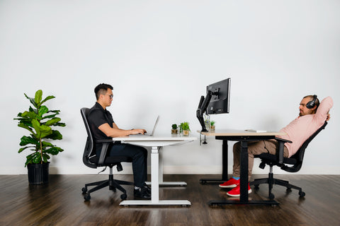 coworkers in an office, taking a break and chatting at their desks