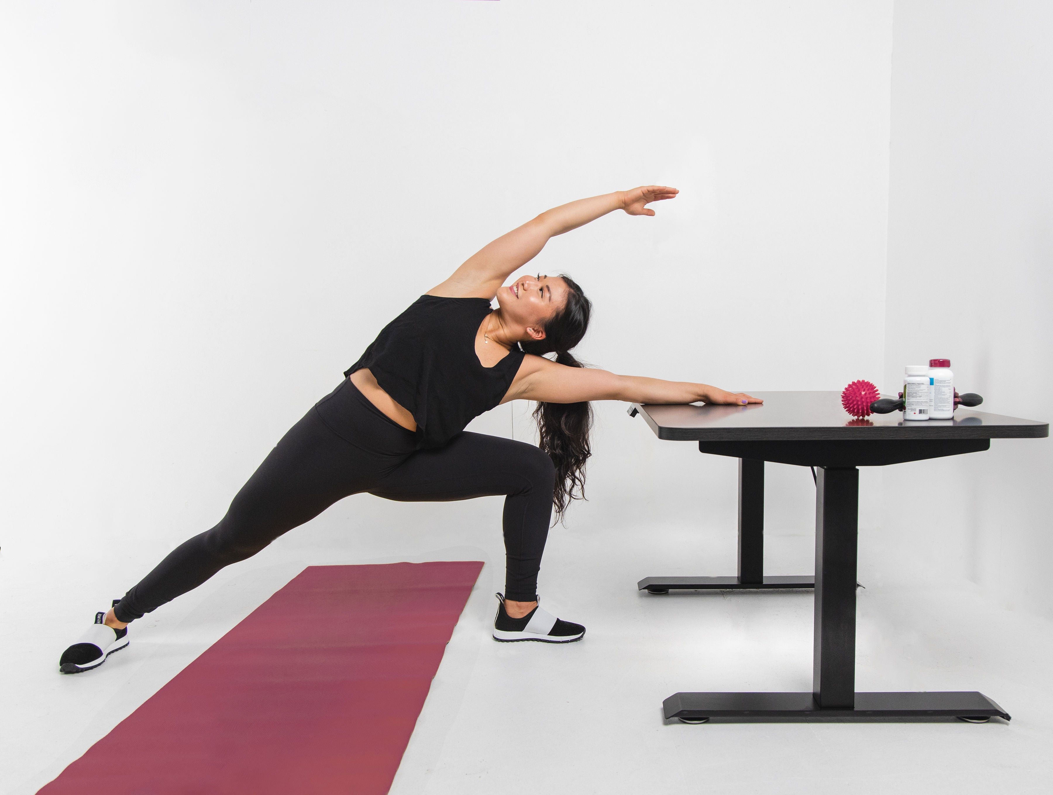 woman stretching at effydesk height adjustable automatic standing desk to reduce back pain