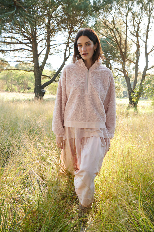 Erin wears the Cloud Teddy Sweatshirt over the Lantern Dress in Pink.