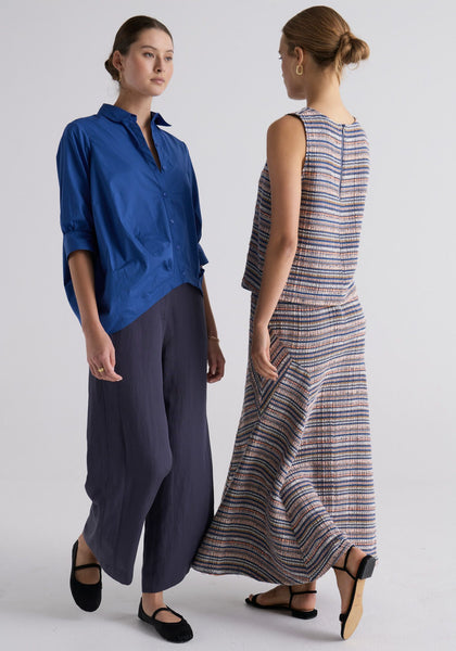 Megumi wears the Louie Draped Shirt in Marie with the Riley Pant in Indigo, and Esti wears the Joey Tweed Tank with the Joey Tweed Skirt.