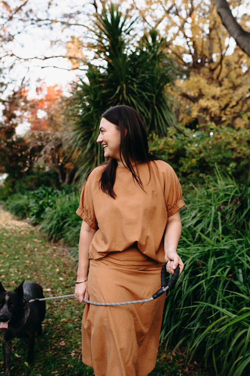 Anna wears the Renata Top and Skirt in Toffee.