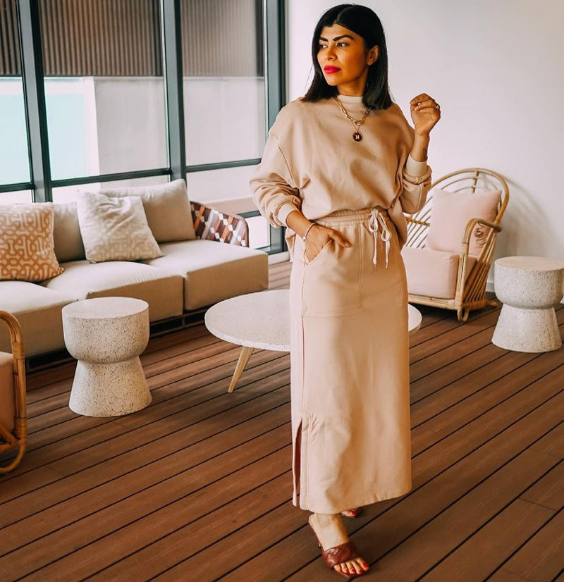 Neha wears the Game Oversized Sweat in Camel with the Game Skirt.