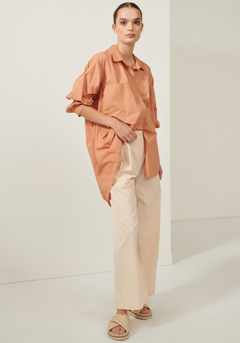 Beck wears Lagoon Shirt in Peach and Selve Pant in Natural.