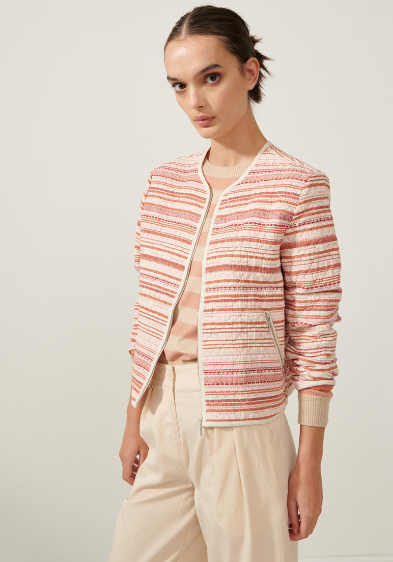 Beck wears the Aspire Quilted Bomber with the Calamity Striped Knit and the Selve Pant in Natural.