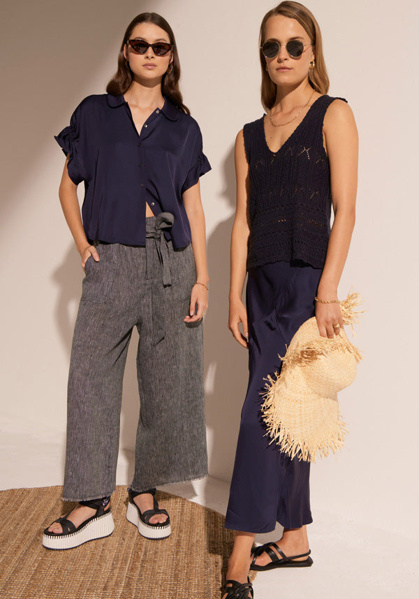 Megumi wears the Clese Shirt in Ink with the Isla Pant, and Esti wears the Maui Pointelle Tank with the Clese Bias Skirt