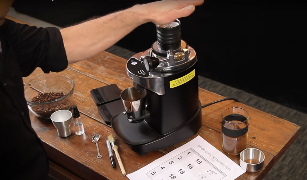 Pushing down the bellows of the Ceado E37SD on a wooden table with Marc's test sheet and accessories on the table.